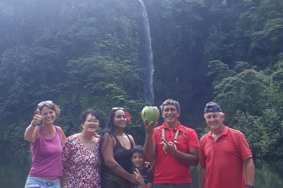 sekumpulan orang berdiri di hadapan air terjun