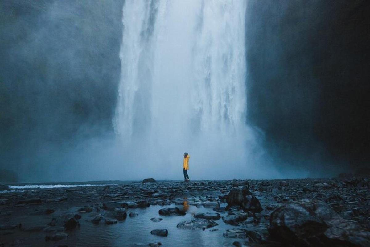maður stendur fyrir framan foss