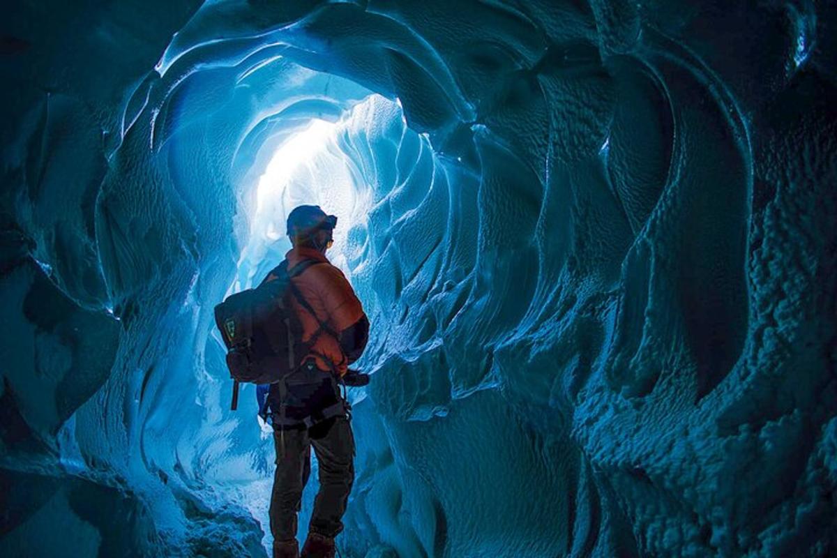 un uomo in piedi all'interno di una grotta di ghiaccio