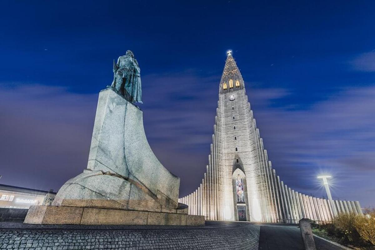 uma estátua em frente a um prédio com uma torre