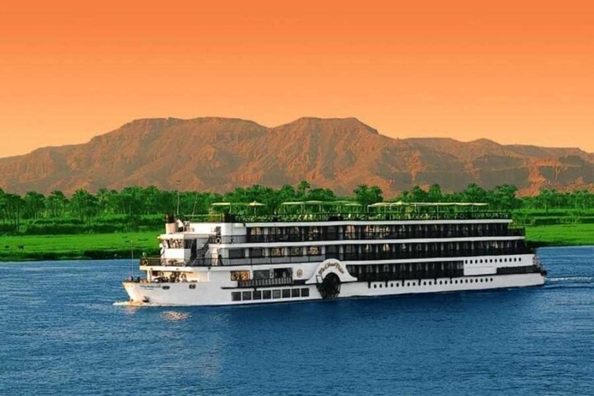 um navio de cruzeiro na água com montanhas ao fundo