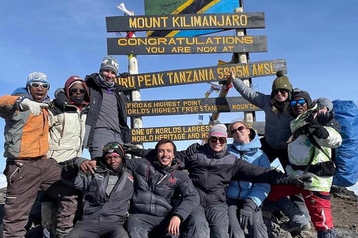 a group of people posing for a picture in front of a sign