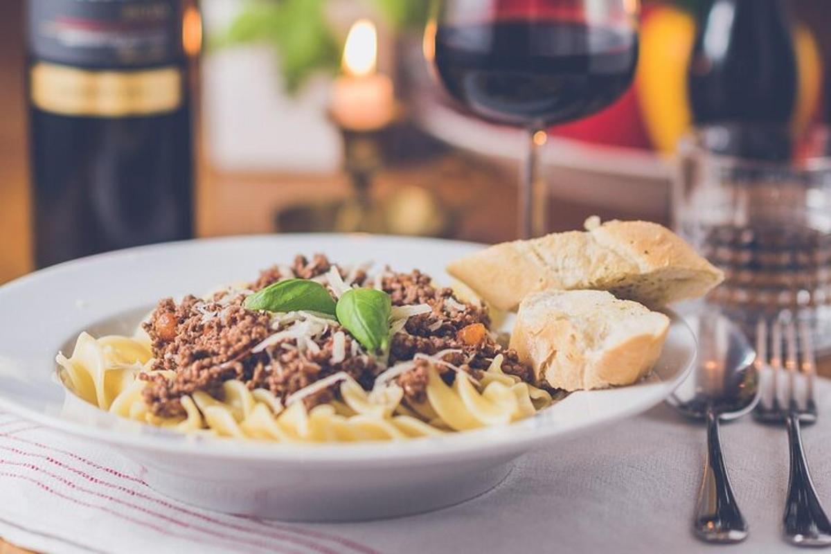 diskur af pasta með kjöti og brauði og víni