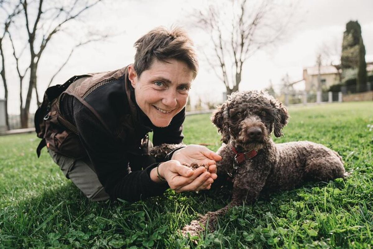 eine Frau, die mit einem Hund im Gras liegt
