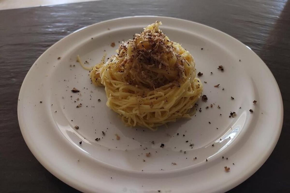een wit bord met pasta op een tafel