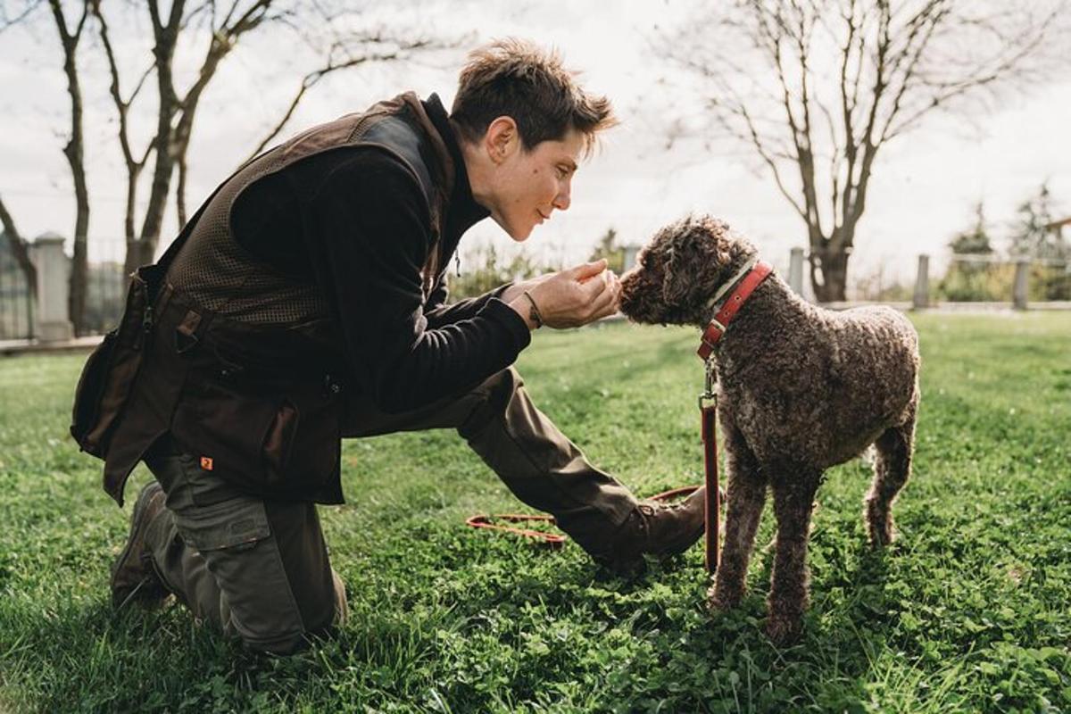 Ein Mann streichelt einen Hund auf einem Feld