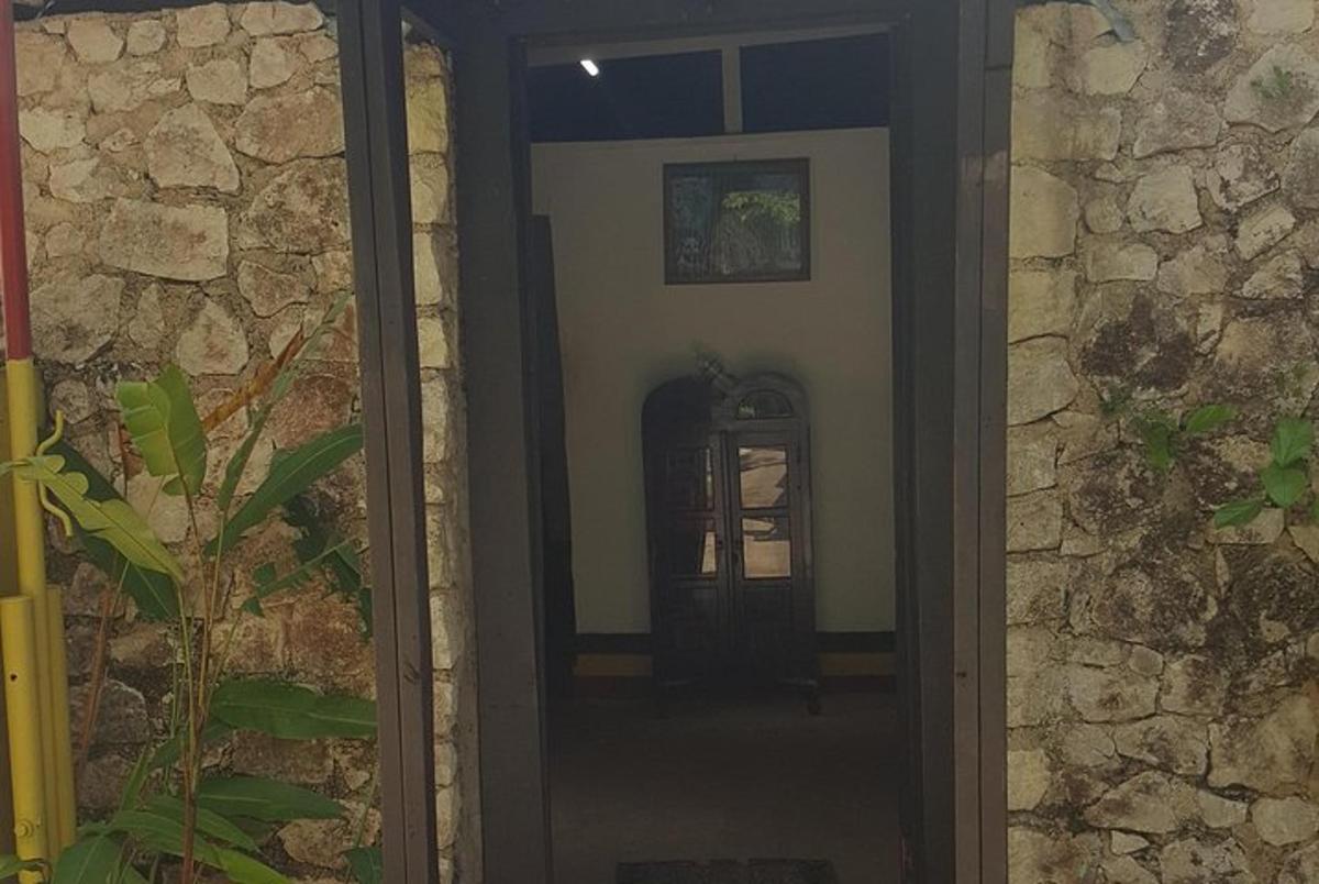 una porta che conduce in una stanza con un muro di pietra