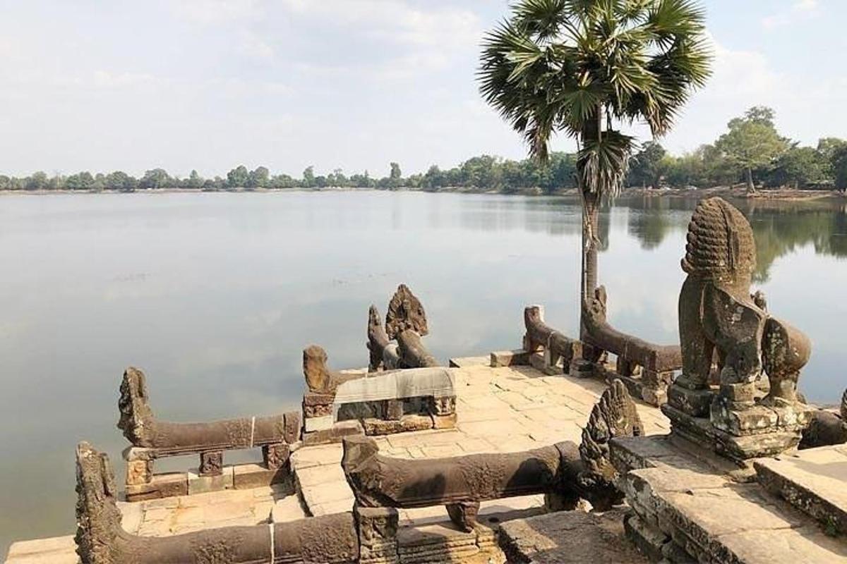 a group of statues next to a body of water