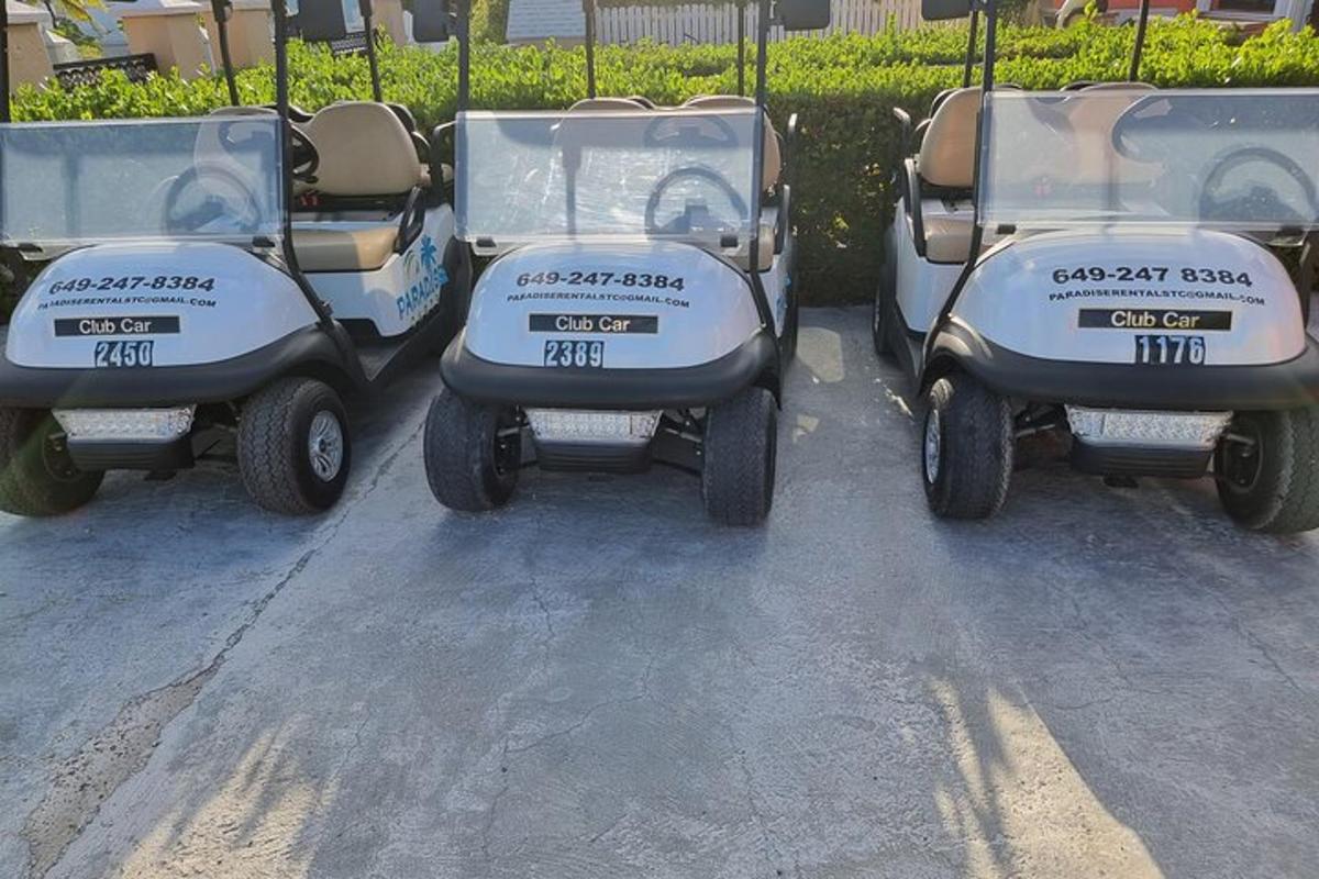 a group of four golf carts parked in a parking lot
