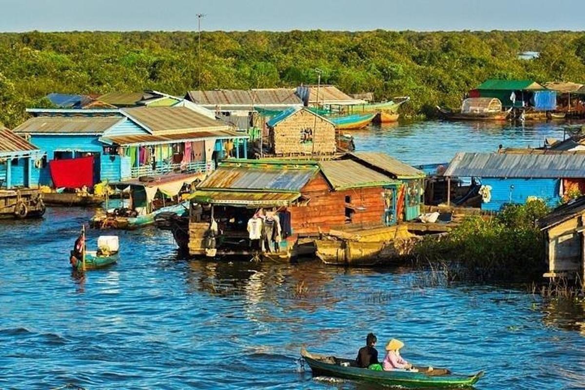 two people in a boat on a river with houses