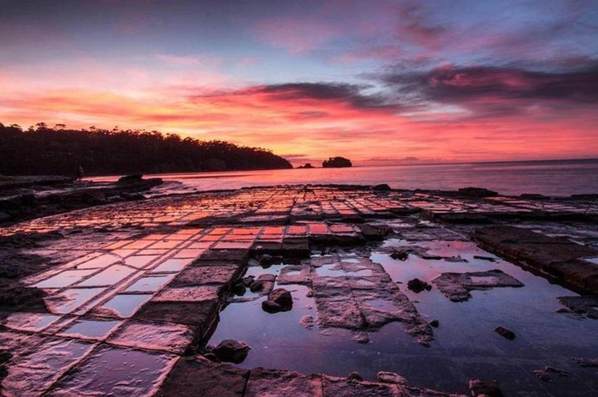 um pôr do sol em uma praia com um corpo d'água