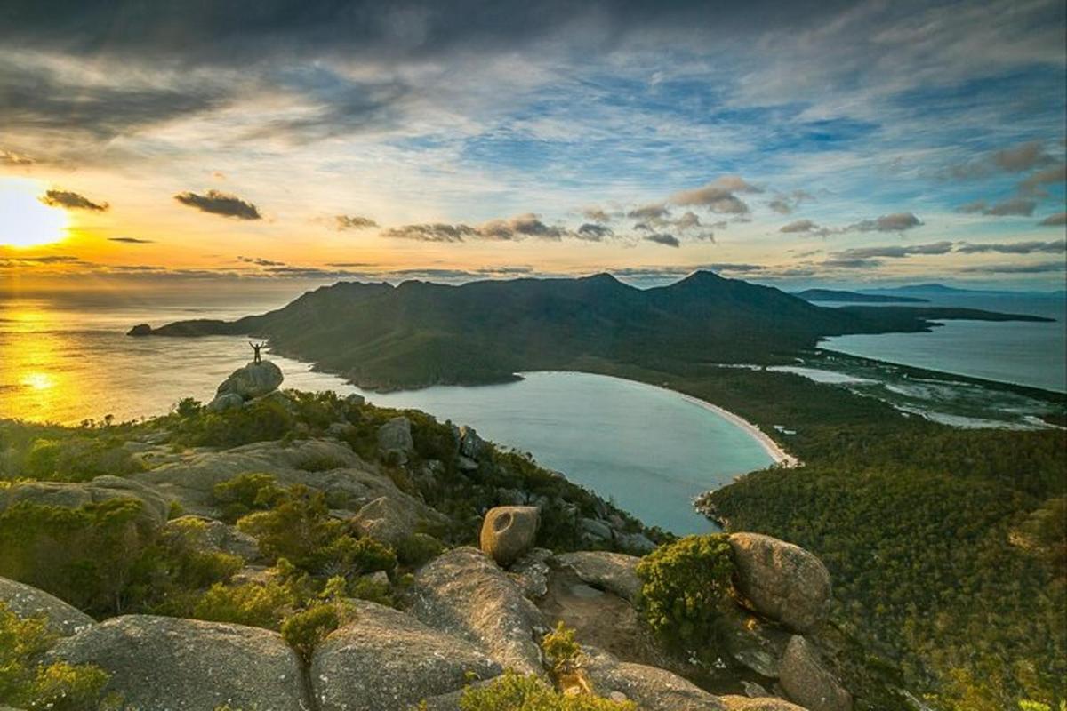 uma vista de uma praia com o oceano e o pôr do sol