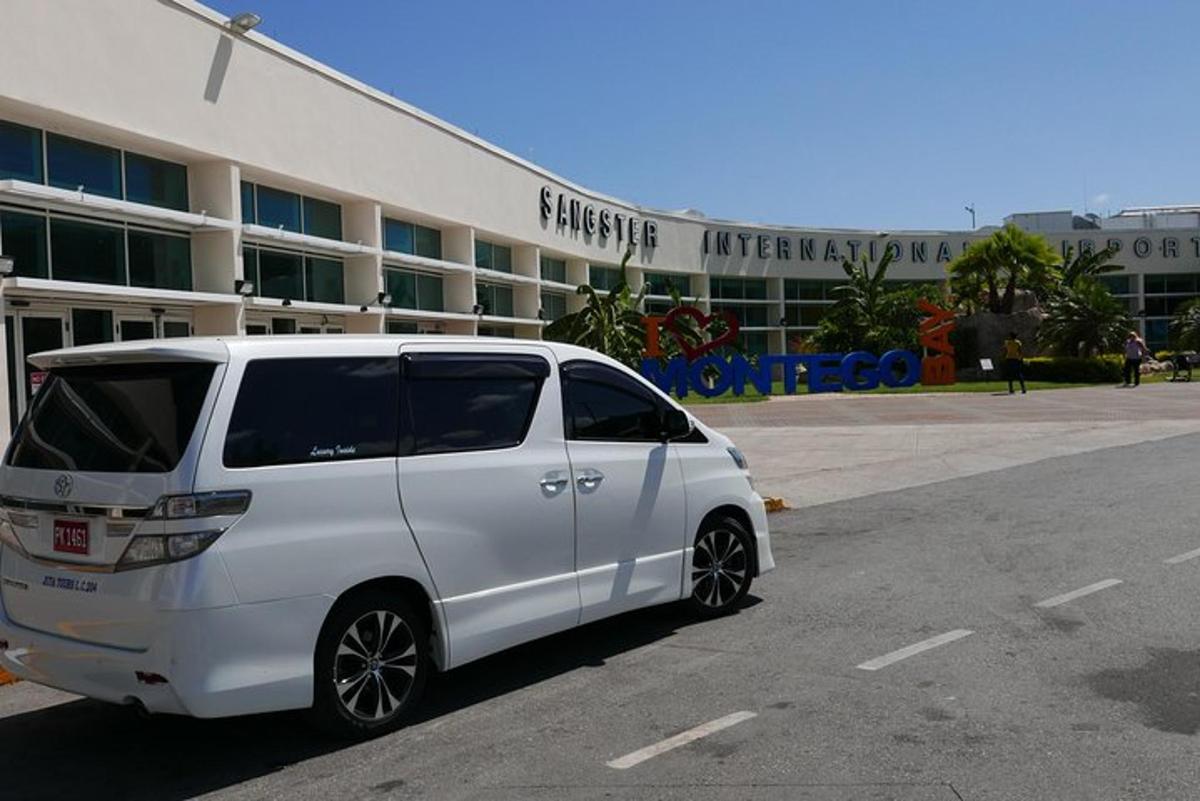 egy fehér furgon parkolt egy épület előtti parkolóban