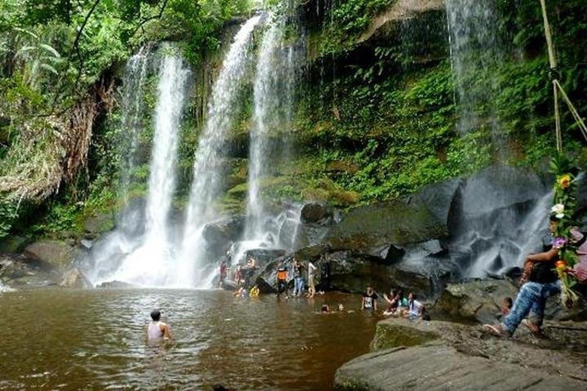 sekumpulan orang di dalam air berhampiran air terjun