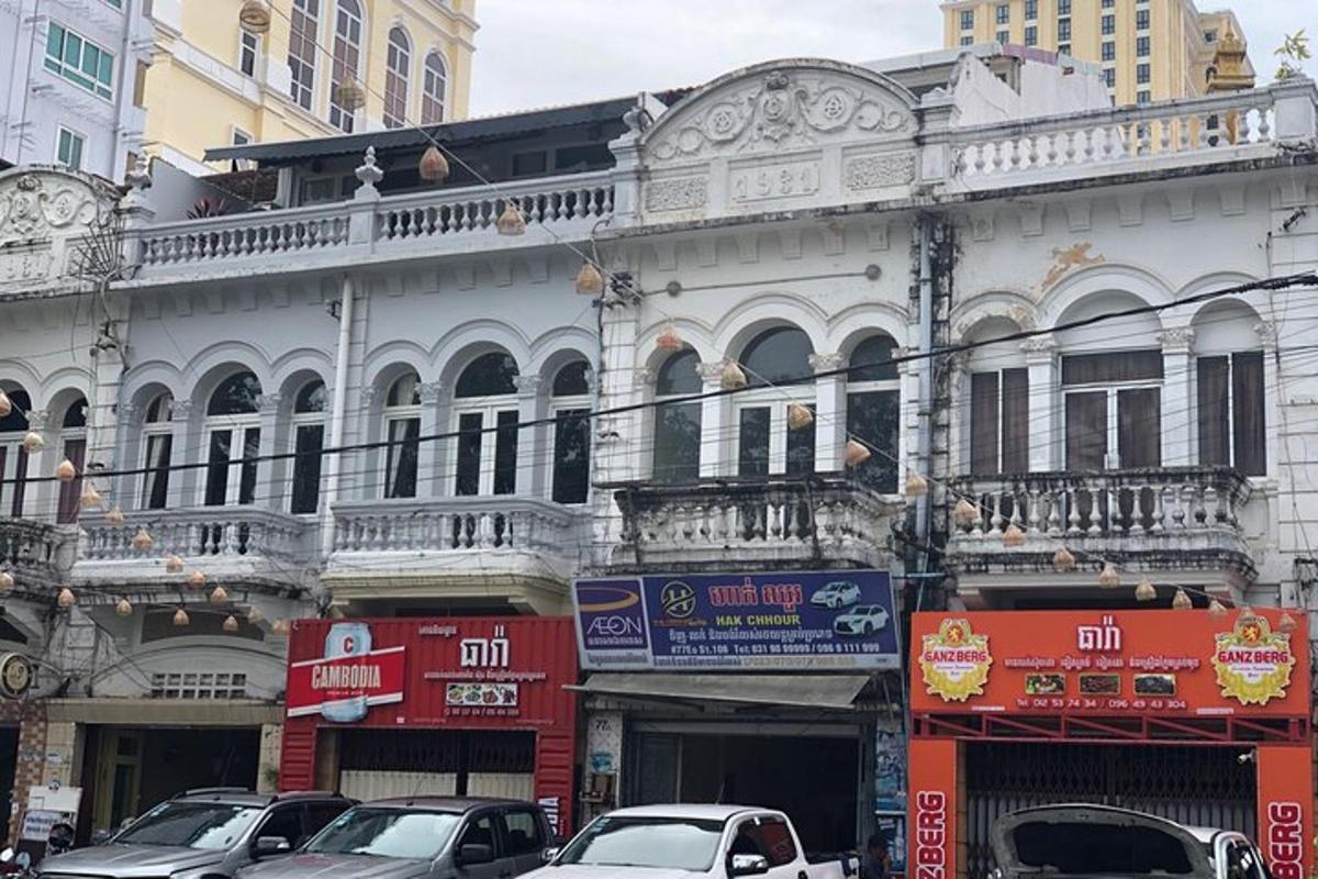 Un gran edificio blanco con coches aparcados delante.