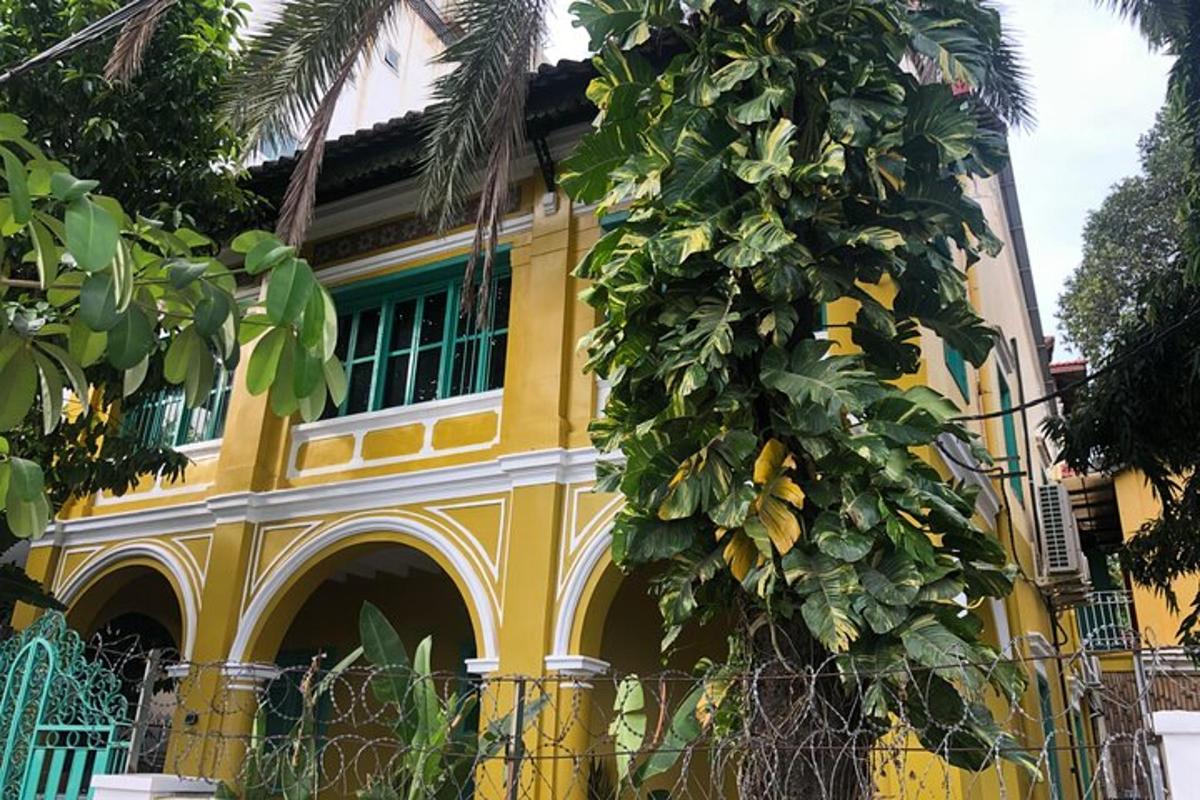 Un edificio amarillo con un árbol delante.