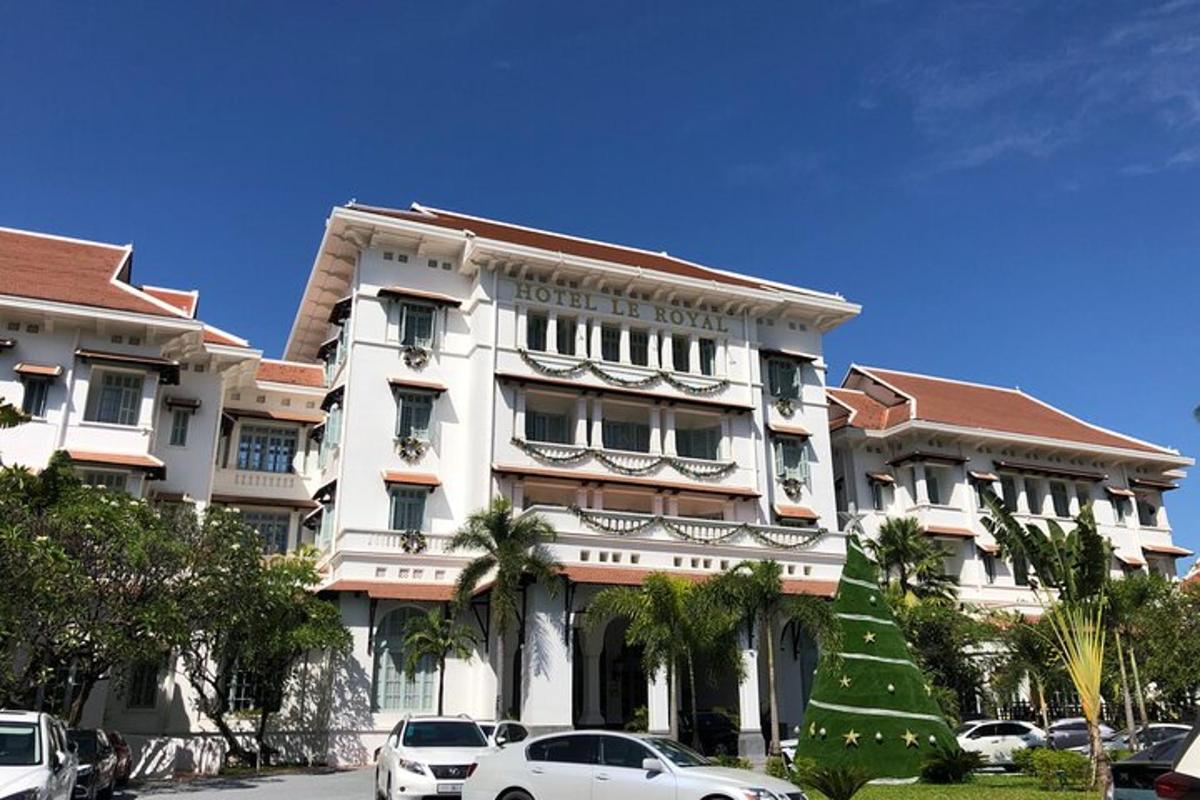 Un gran edificio blanco con coches aparcados delante.