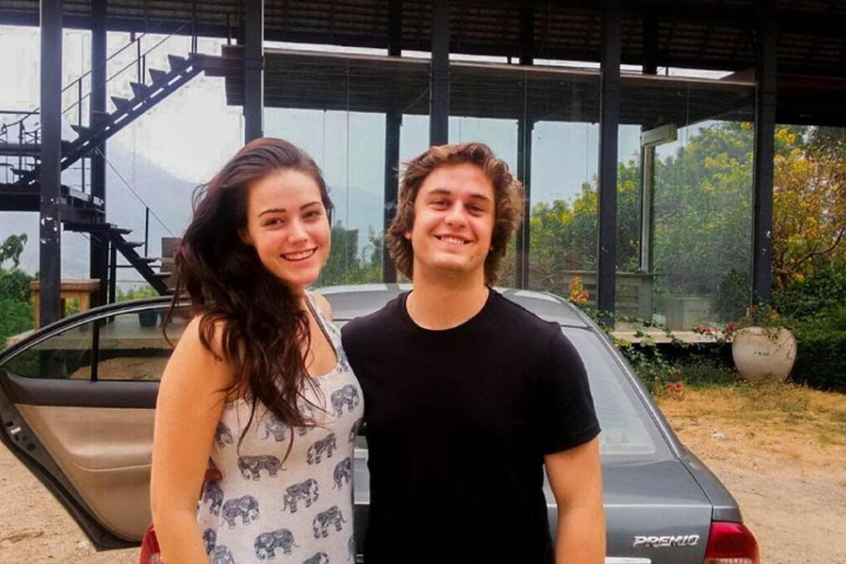 un bărbat și o femeie stând lângă o mașină