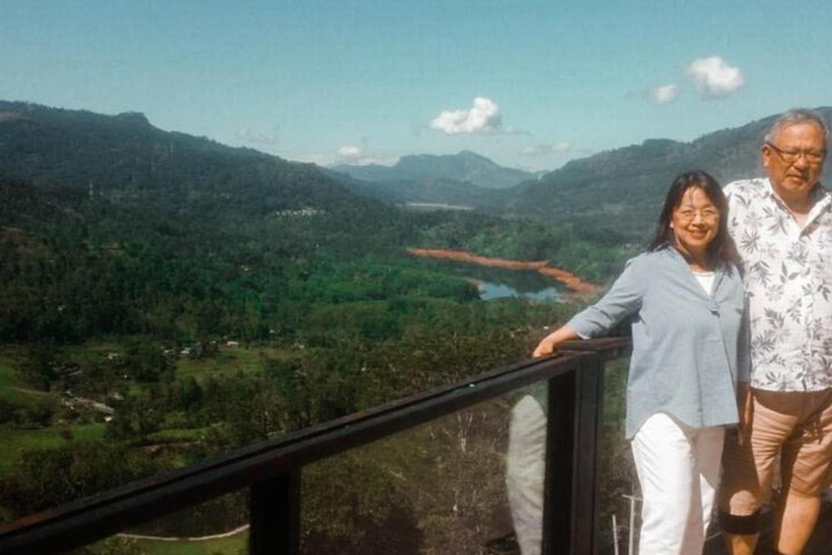 a man and a woman standing on a balcony overlooking a valley