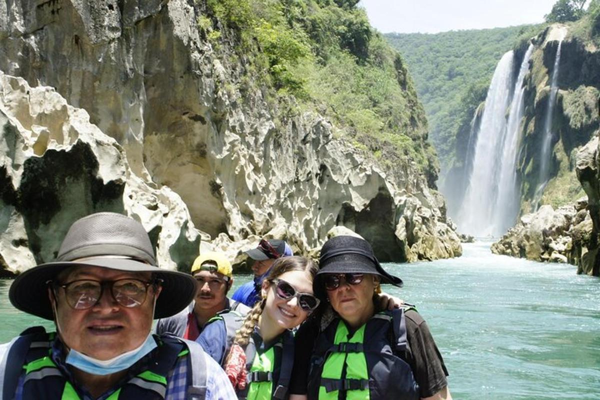 a group of people on a raft in front of a waterfall