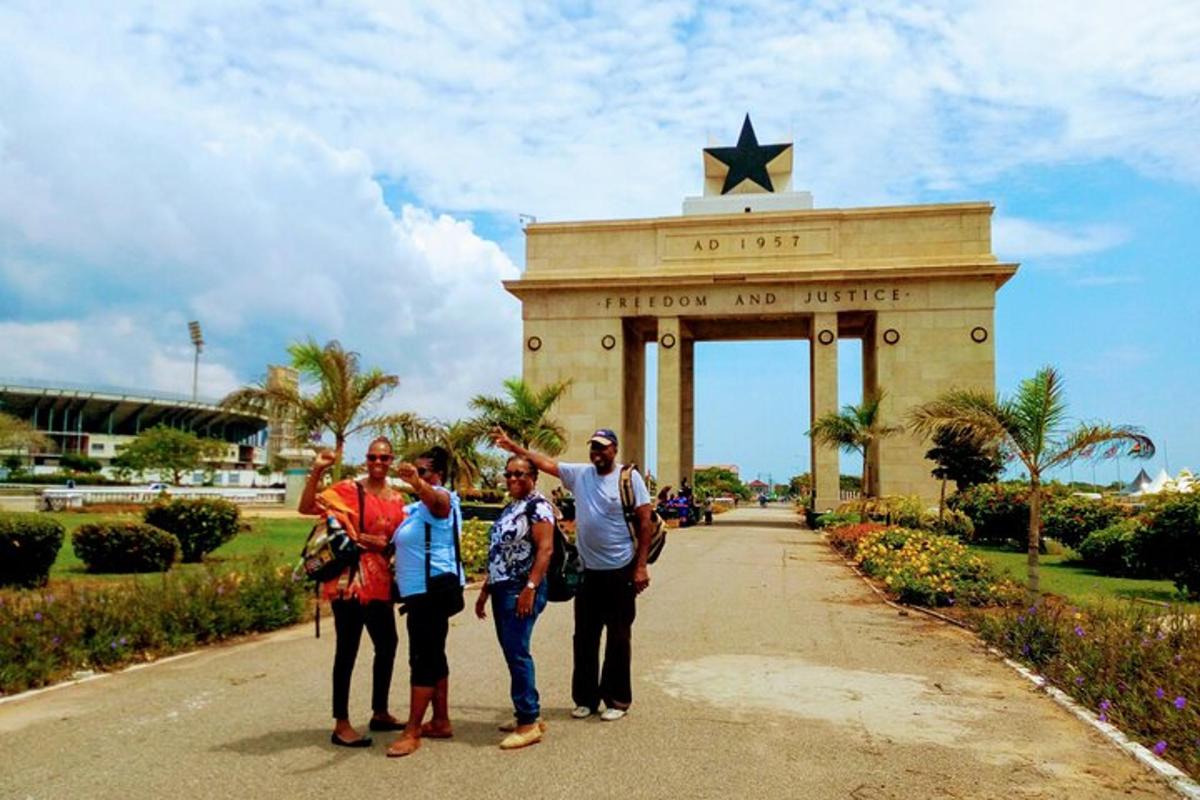 um grupo de pessoas em pé em frente a um monumento