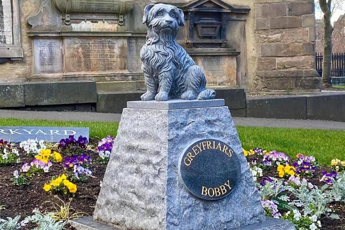 una estàtua d'un gos assegut sobre una roca