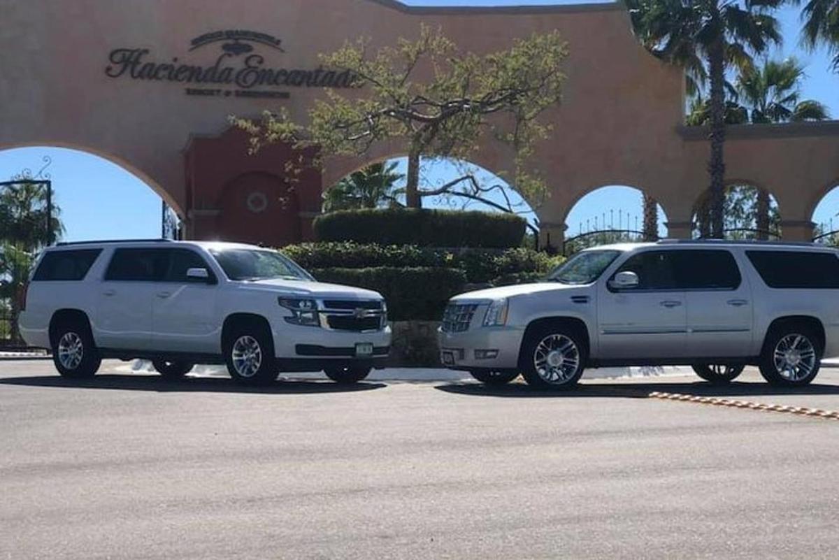 two white suvs parked in front of a building