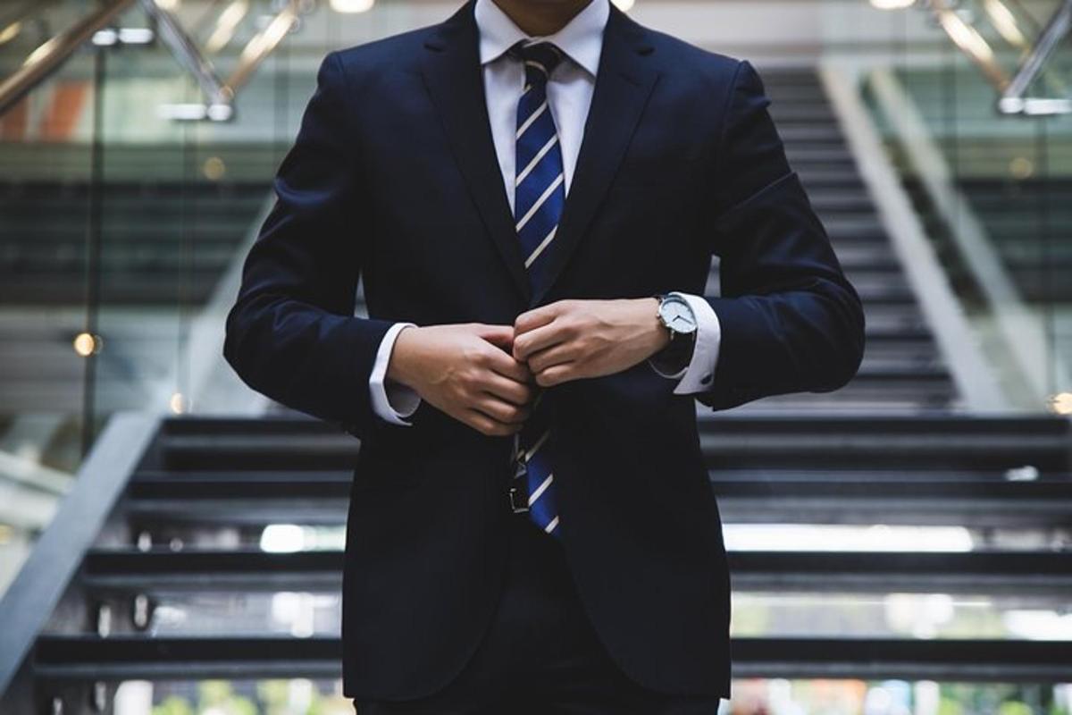 a man in a suit and tie with his hands
