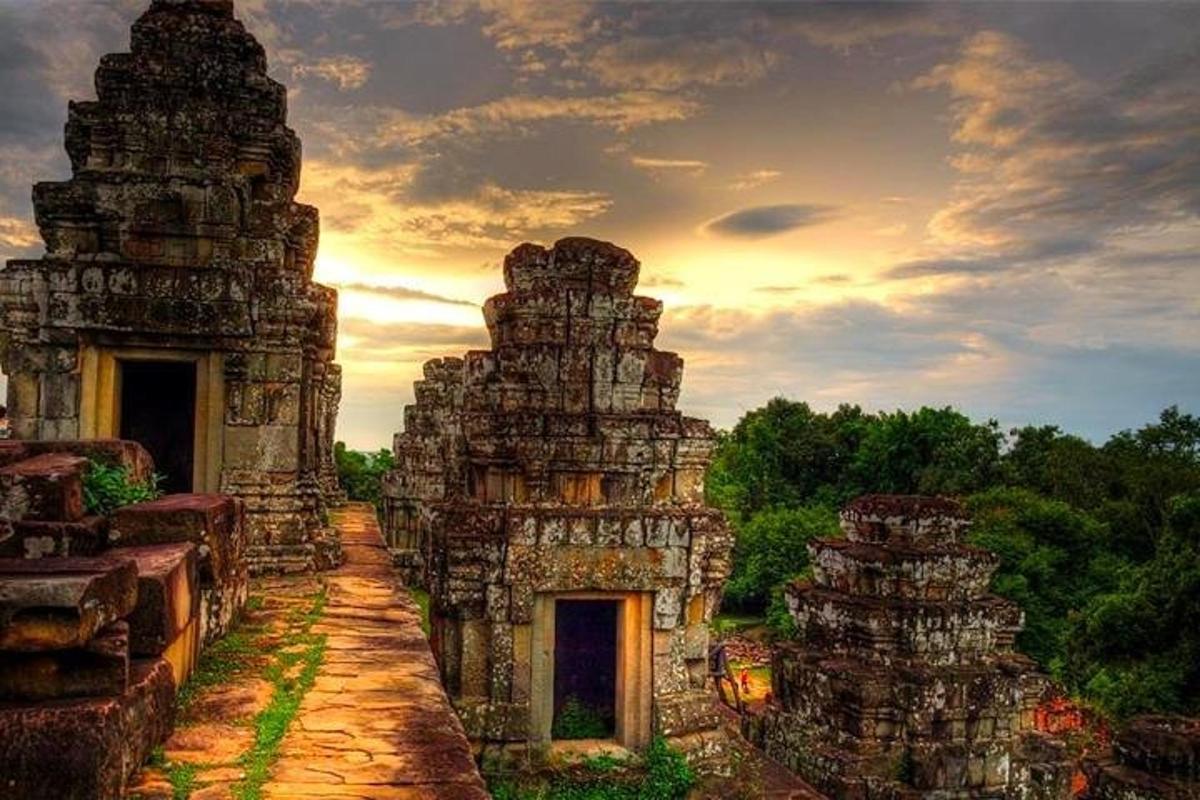 sebuah bangunan batu tua dengan latar belakang matahari terbenam
