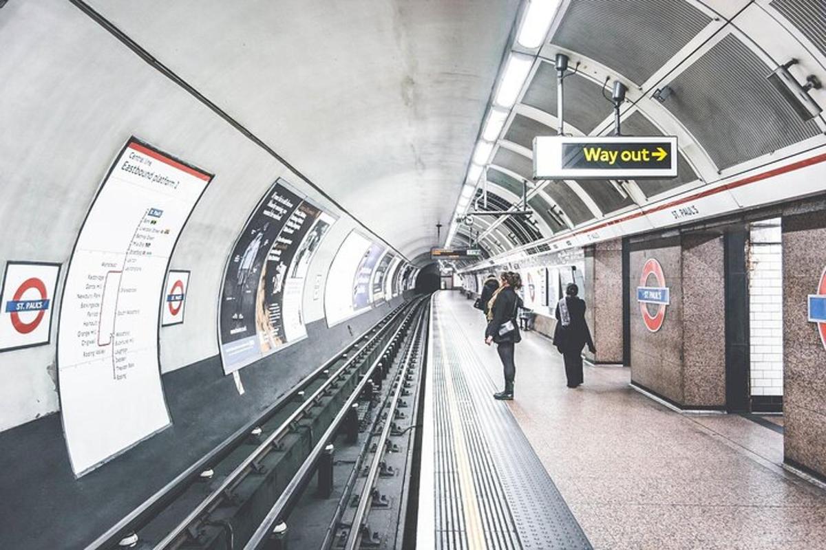 una stazione della metropolitana con persone in attesa sui binari della metropolitana
