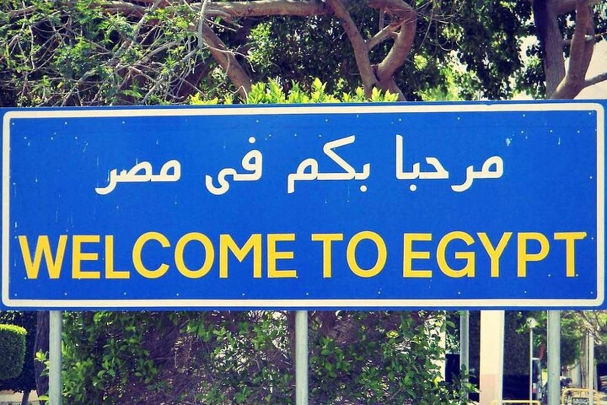 un indicator stradal albastru care spune „Bun venit în Egipt”