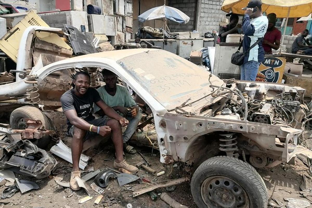 dois homens sentados dentro de um carro queimado