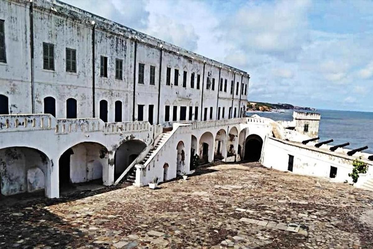 an old building with stairs in front of the water