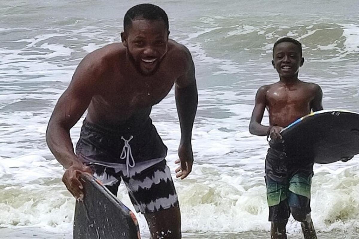two men standing in the ocean with their surfboards