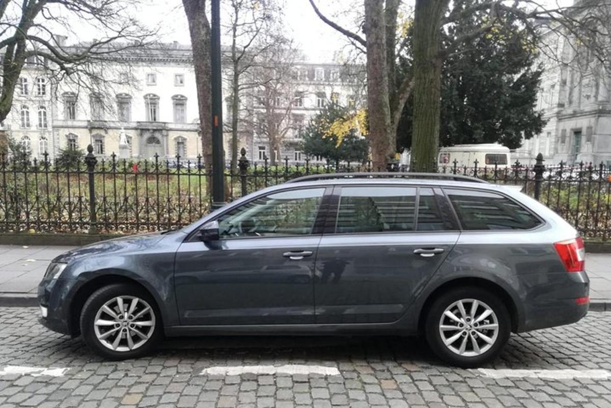 en grå bil parkeret foran en bygning