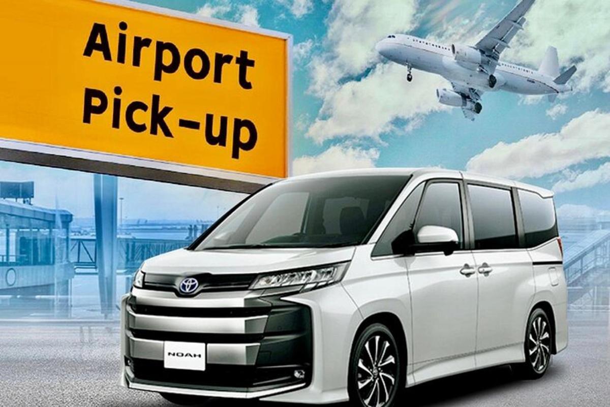 un furgone bianco parcheggiato accanto a un aeroporto con un aereo