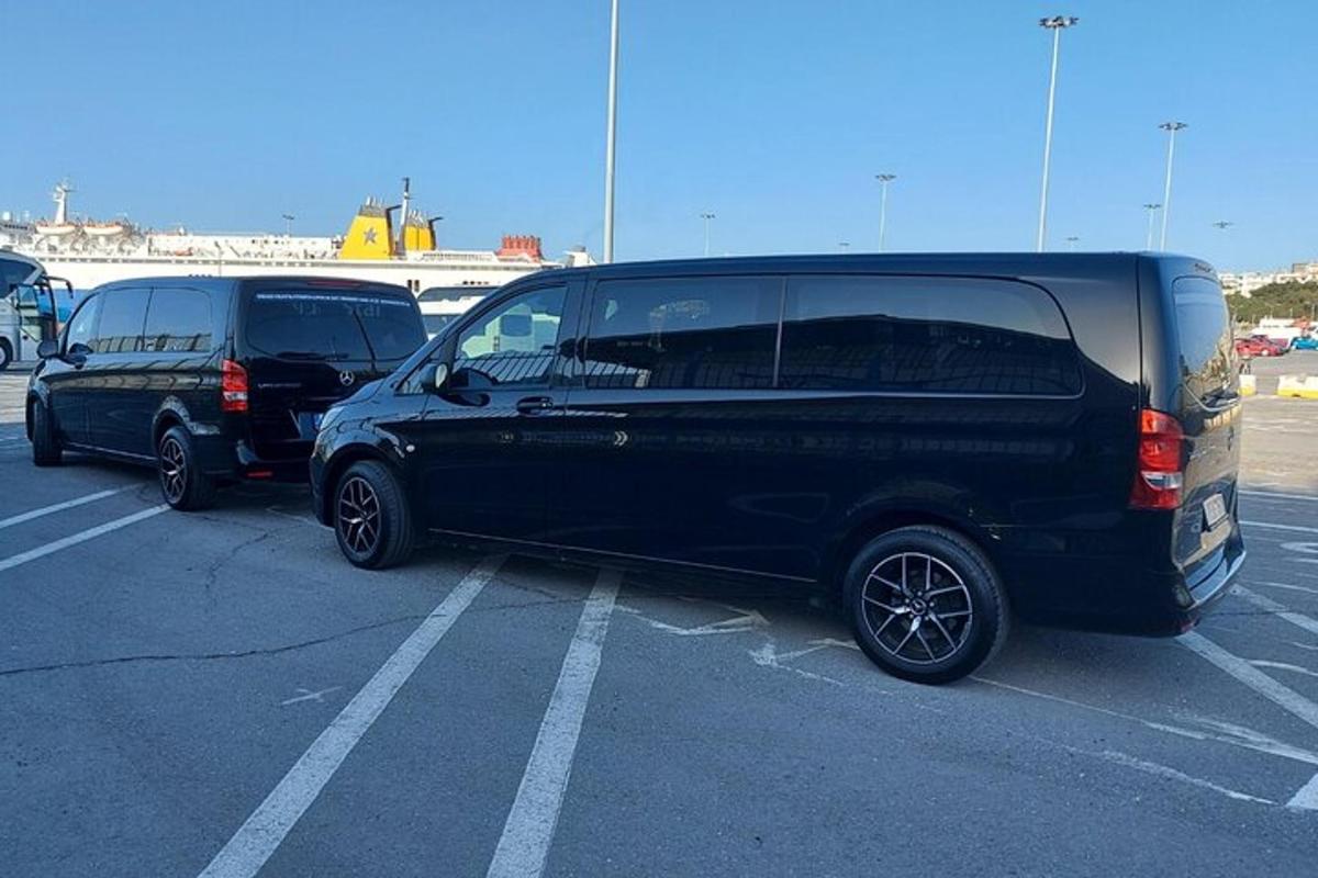 duas vans pretas estacionadas em um estacionamento