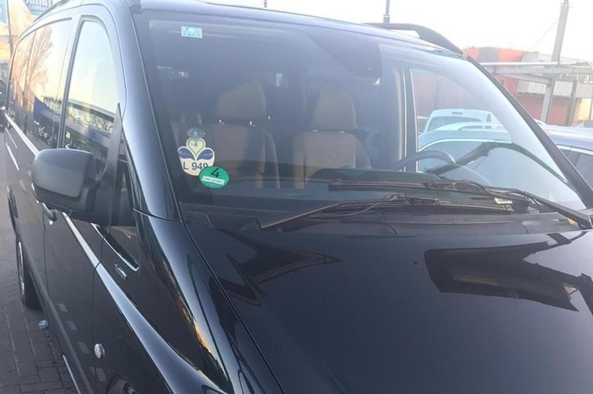 črn kombi z nalepko na vetrobranskem steklu