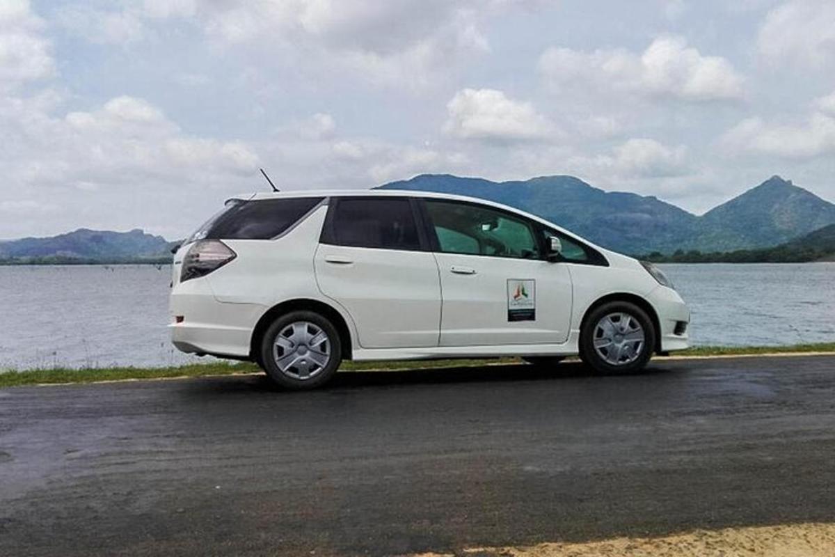 bílé auto zaparkované vedle vodní plochy