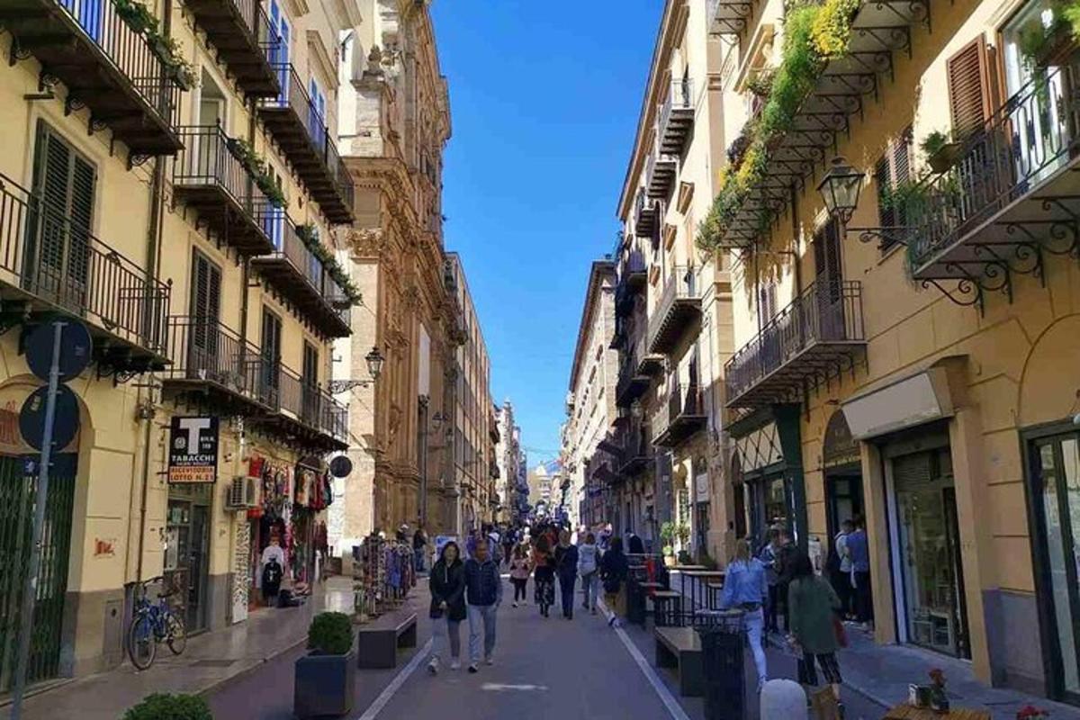 μια ομάδα ανθρώπων που περπατούν σε έναν δρόμο με κτίρια