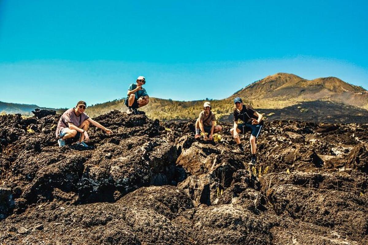 sekumpulan orang duduk di atas batu di atas gunung