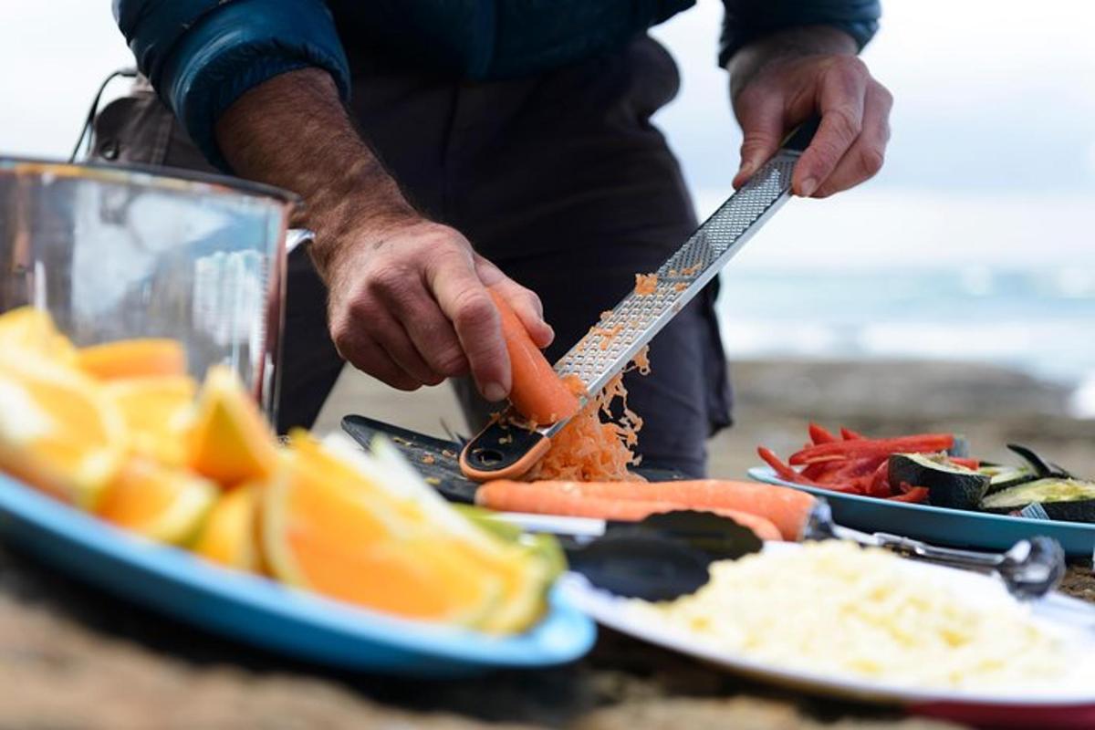 a person holding a knife next to plates of food
