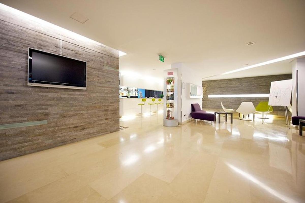 uma sala de estar com uma TV em uma parede de tijolos