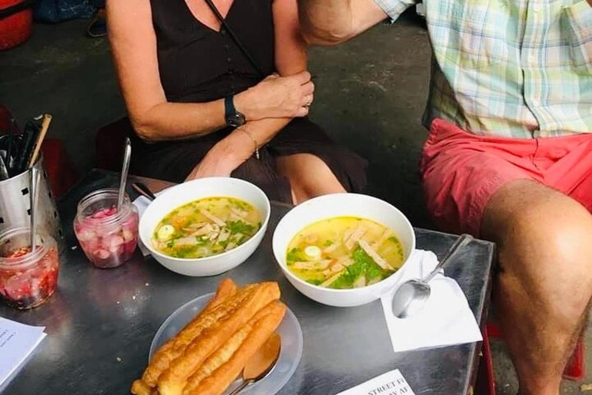 dua orang duduk di atas meja dengan mangkuk makanan