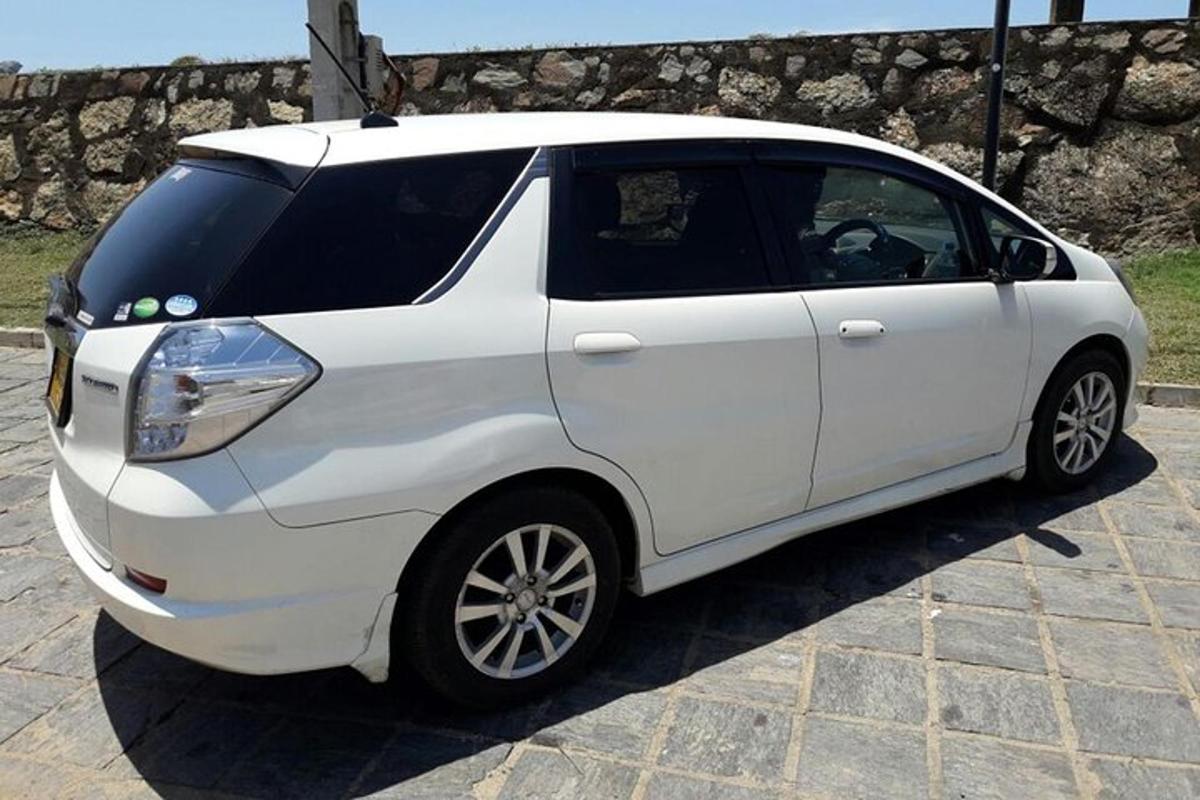 una smart bianca parcheggiata su una strada di mattoni