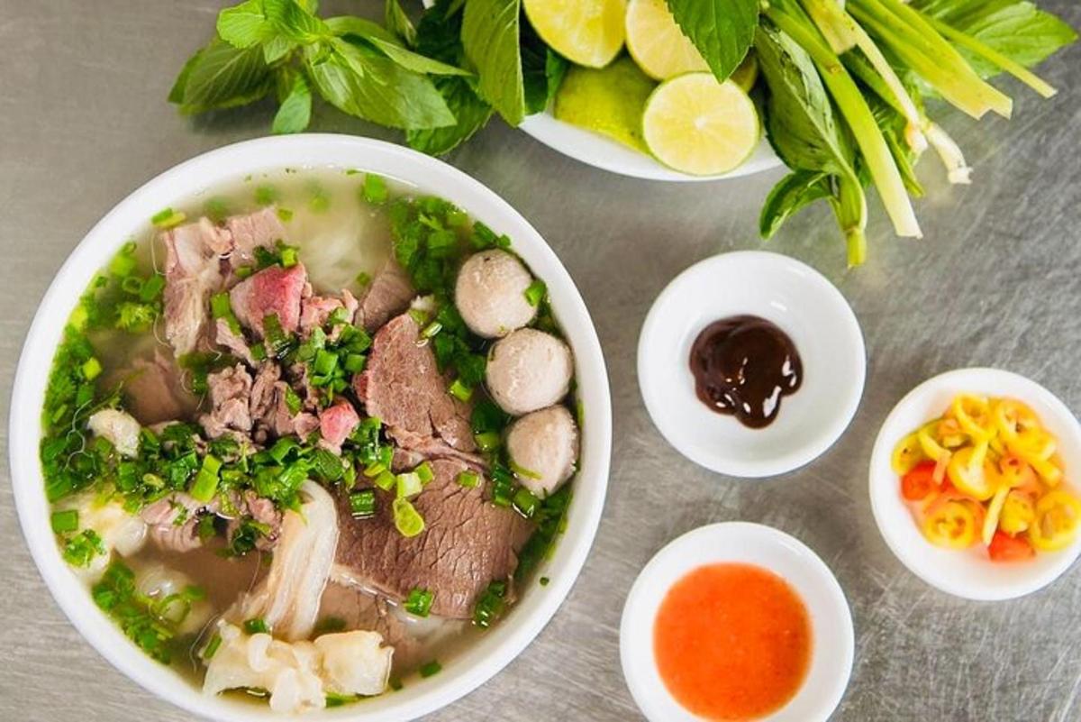Un tazón de sopa con carne y verduras en una mesa.