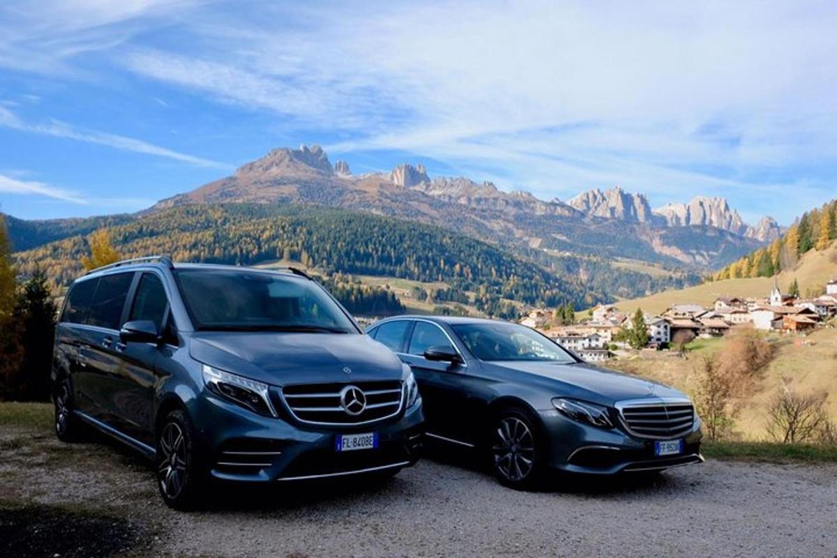 due auto parcheggiate una accanto all'altra davanti a una montagna