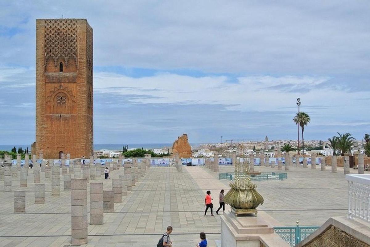 люди гуляют по площади с часовой башней
