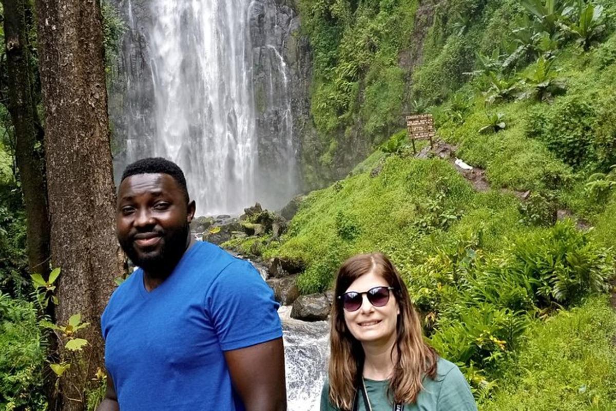 a man and a woman standing in front of a waterfall