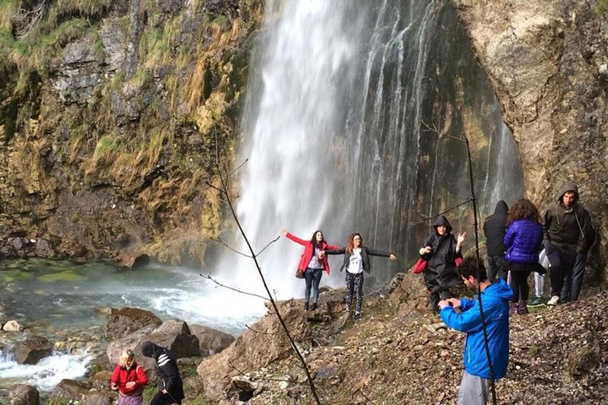 un gruppo di persone in piedi davanti a una cascata